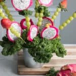 dragon fruit bouquet made of dragon fruit, green grapes, and strawberries on a table