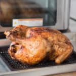 whole cooked chicken on a tray in front of Instant Vortex Plus Air Fryer Oven